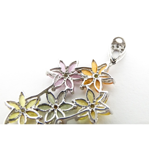 702 - A 9ct white gold pendant set with diamonds and coloured floral detail. Approx. 2