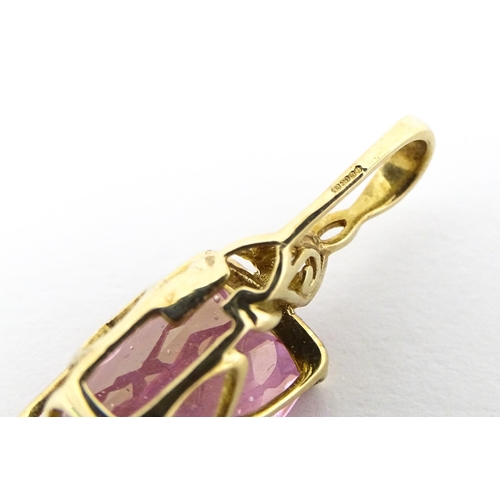 704 - A 9ct gold pendant set with large central pink stone and white stone above. Approx. 1 1/4