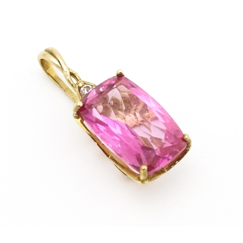 704 - A 9ct gold pendant set with large central pink stone and white stone above. Approx. 1 1/4