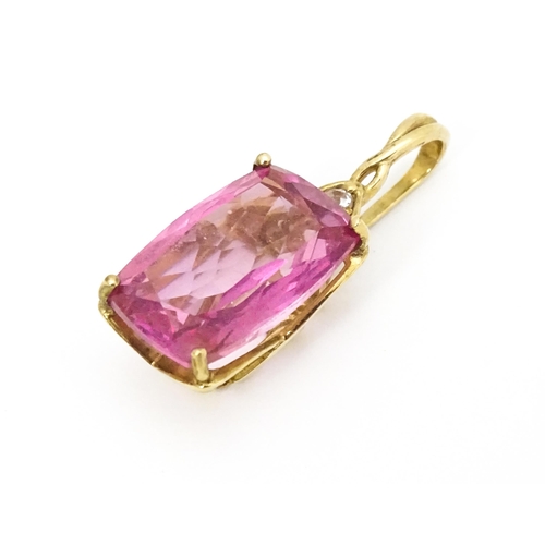 704 - A 9ct gold pendant set with large central pink stone and white stone above. Approx. 1 1/4