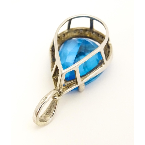 706 - A 9ct white gold pendant set with central topaz bordered by diamonds. Approx. 1