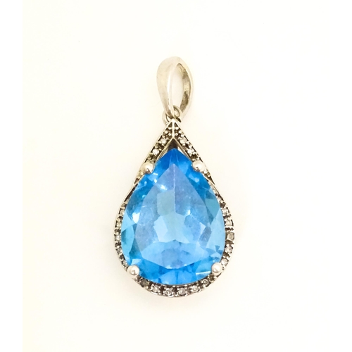 706 - A 9ct white gold pendant set with central topaz bordered by diamonds. Approx. 1