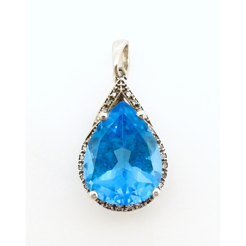 706 - A 9ct white gold pendant set with central topaz bordered by diamonds. Approx. 1