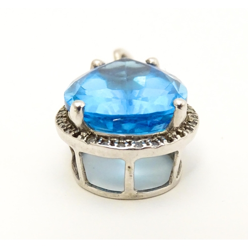 706 - A 9ct white gold pendant set with central topaz bordered by diamonds. Approx. 1