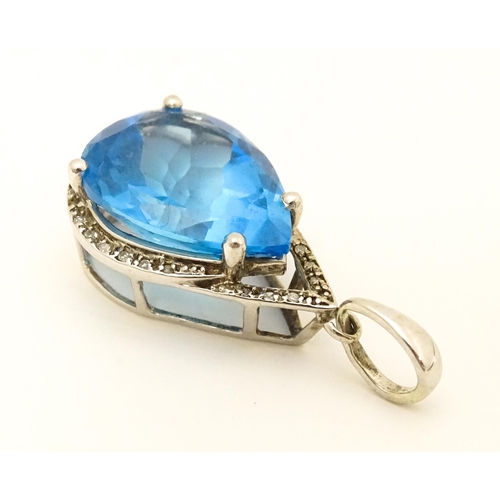 706 - A 9ct white gold pendant set with central topaz bordered by diamonds. Approx. 1