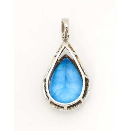 706 - A 9ct white gold pendant set with central topaz bordered by diamonds. Approx. 1