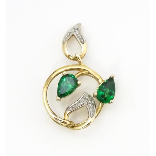 720 - A 9ct gold pendant set with diamonds and green stones. Approx. 1