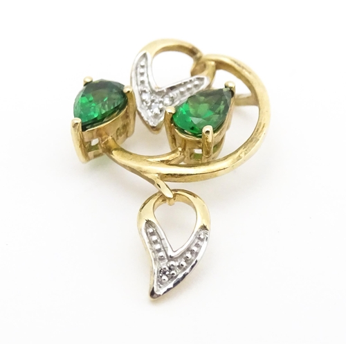 720 - A 9ct gold pendant set with diamonds and green stones. Approx. 1