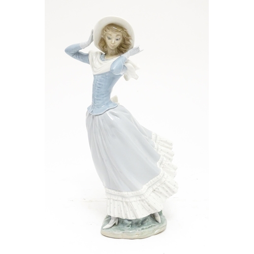 103 - A Lladro figure Spring Breeze, no. 4936, modelled as a lady with a hat. Marked under. Approx. 14 1/4... 