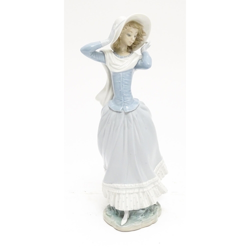 103 - A Lladro figure Spring Breeze, no. 4936, modelled as a lady with a hat. Marked under. Approx. 14 1/4... 