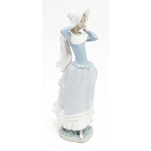 103 - A Lladro figure Spring Breeze, no. 4936, modelled as a lady with a hat. Marked under. Approx. 14 1/4... 