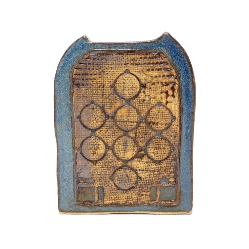 113 - A studio pottery slab vase of arch form with circular decoration. In the manner of Troika. Approx. 5... 