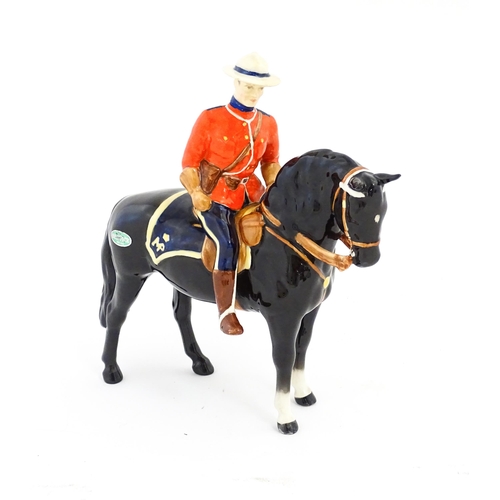 117 - A Beswick Canadian Mountie on a black horse, model no. 1375. Marked under. Approx. 8 1/4