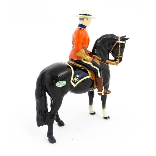 117 - A Beswick Canadian Mountie on a black horse, model no. 1375. Marked under. Approx. 8 1/4