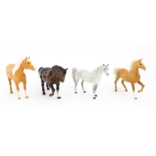 119 - Four Beswick models of horses comprising a palomino Prancing Arab model no. 1261, a brown horse with... 