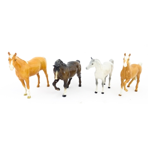 119 - Four Beswick models of horses comprising a palomino Prancing Arab model no. 1261, a brown horse with... 