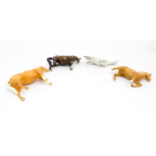 119 - Four Beswick models of horses comprising a palomino Prancing Arab model no. 1261, a brown horse with... 