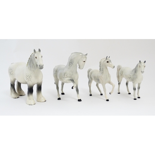 124 - Four Beswick models of horses in dapple grey to include a head tucked leg up no. 1549, shire mare no... 