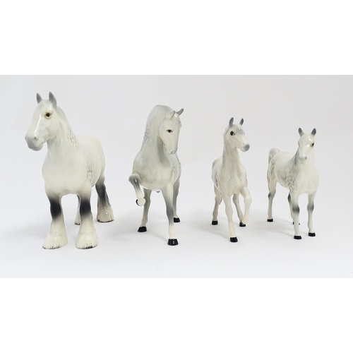 124 - Four Beswick models of horses in dapple grey to include a head tucked leg up no. 1549, shire mare no... 