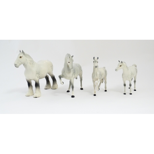 124 - Four Beswick models of horses in dapple grey to include a head tucked leg up no. 1549, shire mare no... 