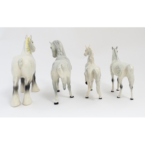 124 - Four Beswick models of horses in dapple grey to include a head tucked leg up no. 1549, shire mare no... 