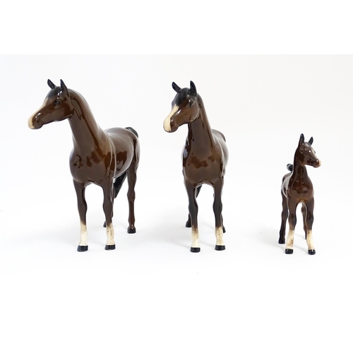 140 - Two Royal Doulton brown horses and a brown foal. Largest approx. 6 1/2