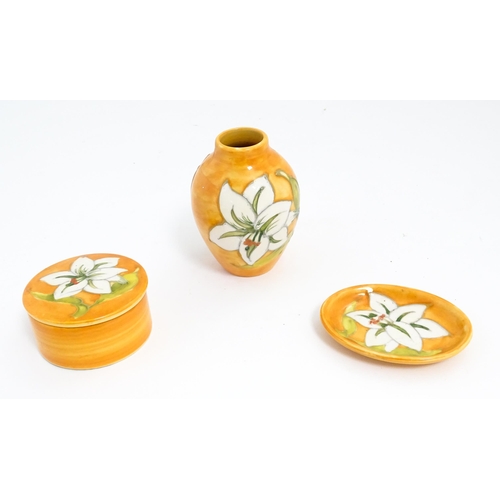 141 - Three items of Moorcroft decorated in the Bermuda Lily pattern comprising small vase, pin dish and p... 