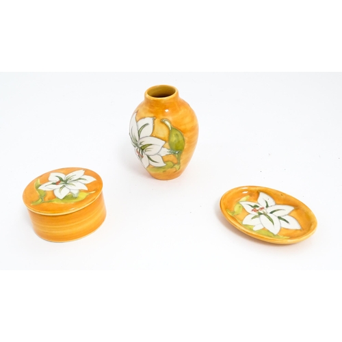 141 - Three items of Moorcroft decorated in the Bermuda Lily pattern comprising small vase, pin dish and p... 