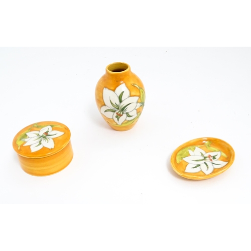 141 - Three items of Moorcroft decorated in the Bermuda Lily pattern comprising small vase, pin dish and p... 