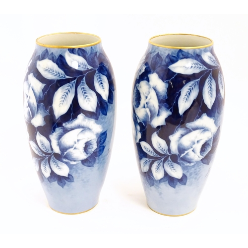 155 - A pair of large French porcelain vases, the blue ground decorated with roses and foliage. With bande... 