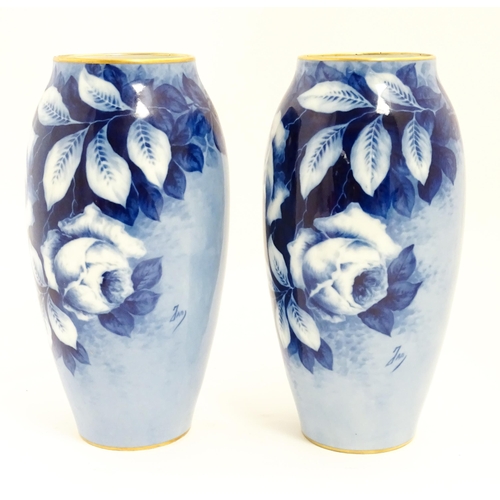 155 - A pair of large French porcelain vases, the blue ground decorated with roses and foliage. With bande... 