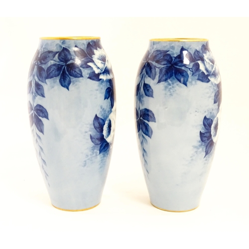 155 - A pair of large French porcelain vases, the blue ground decorated with roses and foliage. With bande... 