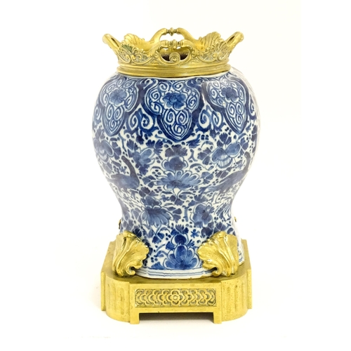 158 - A blue and white baluster vase decorated with birds, flowers and foliage, with brass mounts.  Approx... 