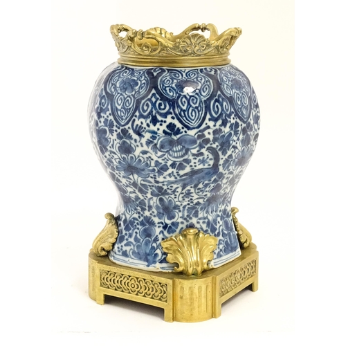 158 - A blue and white baluster vase decorated with birds, flowers and foliage, with brass mounts.  Approx... 