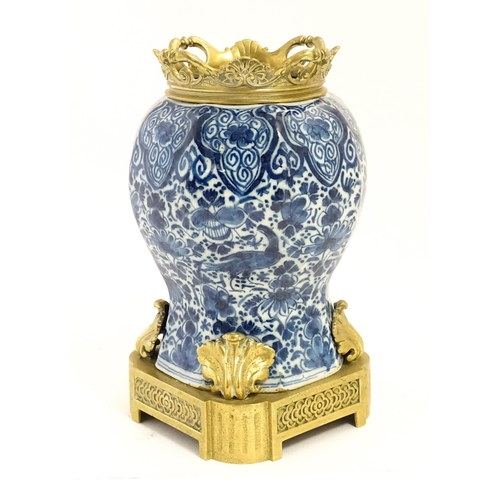 158 - A blue and white baluster vase decorated with birds, flowers and foliage, with brass mounts.  Approx... 