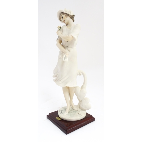 174 - An Italian Florence figure designed by Giuseppe Armani titled In Love depicting a lady holding a flo... 