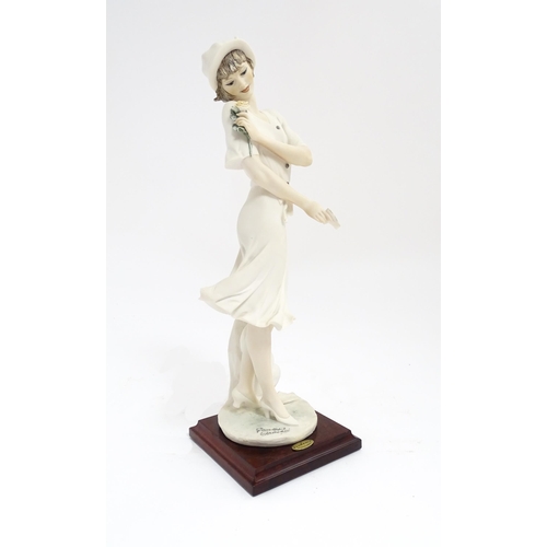 174 - An Italian Florence figure designed by Giuseppe Armani titled In Love depicting a lady holding a flo... 