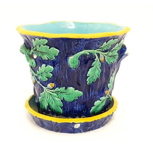 73 - A late 19th / early 20thC majolica planter and stand, the planter with bark, oak leaf and acorn deta... 