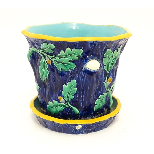 73 - A late 19th / early 20thC majolica planter and stand, the planter with bark, oak leaf and acorn deta... 