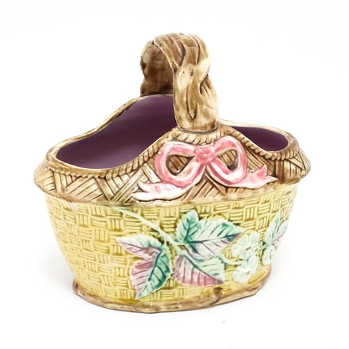 74 - A Victorian majolica basket with pink glazed interior, the woven style exterior with floral, foliate... 