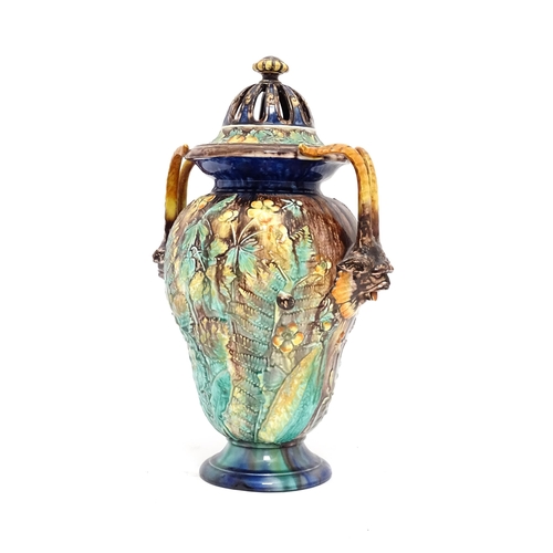 77 - A Royal Palissy majolica lidded vase with twin mask handles, the body decorated with a mottled glaze... 