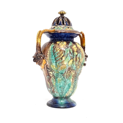 77 - A Royal Palissy majolica lidded vase with twin mask handles, the body decorated with a mottled glaze... 