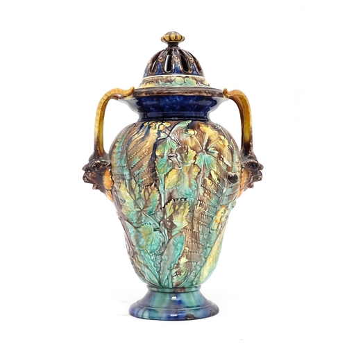 77 - A Royal Palissy majolica lidded vase with twin mask handles, the body decorated with a mottled glaze... 