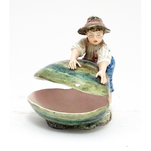 79 - A Continental majolica style dish modelled as a boy with a large shell. Impressed under 416. Approx.... 