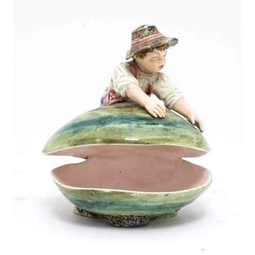 79 - A Continental majolica style dish modelled as a boy with a large shell. Impressed under 416. Approx.... 