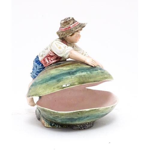 79 - A Continental majolica style dish modelled as a boy with a large shell. Impressed under 416. Approx.... 