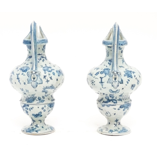 81 - A pair of Italian Cantagalli blue and white ewers decorated with cupids, flowers, foliage, butterfli... 