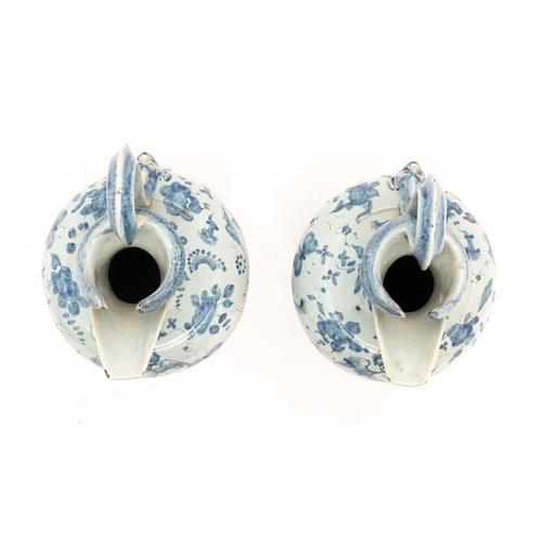 81 - A pair of Italian Cantagalli blue and white ewers decorated with cupids, flowers, foliage, butterfli... 