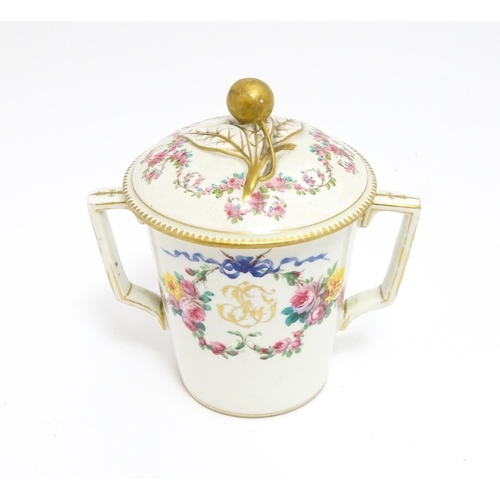 84 - A Sevres twin handled pot and cover decorated with floral garlands and bow detail, with gilt monogra... 