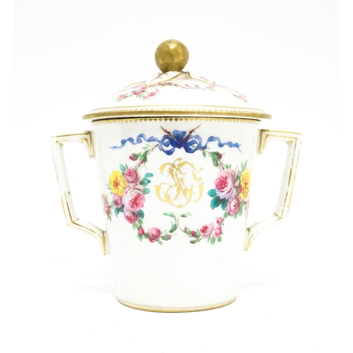 84 - A Sevres twin handled pot and cover decorated with floral garlands and bow detail, with gilt monogra... 